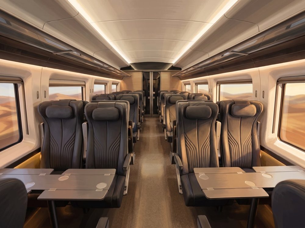 Comfort Class cabin on the Abu Dhabi to Dubai train — rows of wide reclining seats with tray tables and large desert-view windows